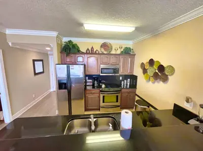 a kitchen with a stainless steel refrigerator and a sink at Ocean Reef 1608 in Panama City Beach