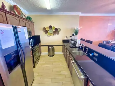 a kitchen with a stainless steel refrigerator and counters at Ocean Reef 1608 in Panama City Beach