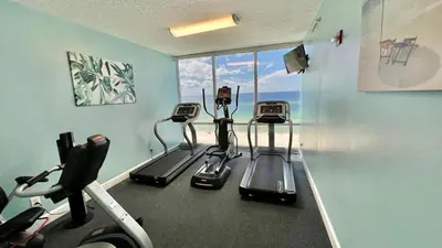 a gym with three treadmills in a room at Ocean Reef 1608 in Panama City Beach