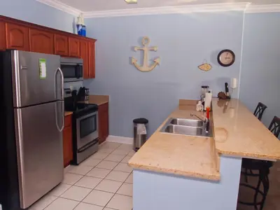 a kitchen with a stainless steel refrigerator and a sink at Ocean Reef 1202 in Panama City Beach