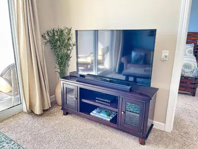 a flat screen tv sitting on a wooden entertainment center at Ocean Reef 1202 in Panama City Beach