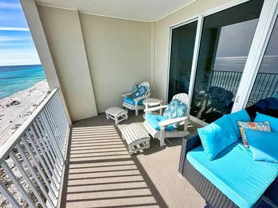 a balcony with a couch and chairs on the beach at Ocean Reef 1202 in Panama City Beach