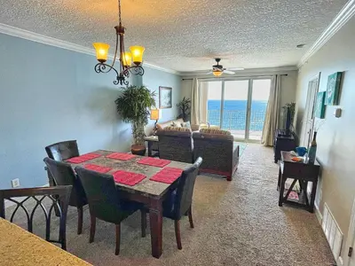 a dining room and living room with a table and chairs at Ocean Reef 1202 in Panama City Beach