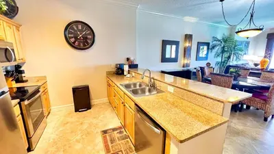 a kitchen with a sink and a clock on the wall at Ocean Reef 2101 in Panama City Beach