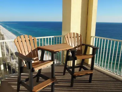 two chairs and a table on a balcony with the ocean at Ocean Reef 2101 in Panama City Beach