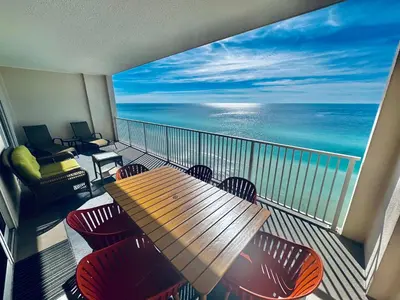 a balcony with a table and chairs and the ocean at Ocean Reef 1707 in Panama City Beach