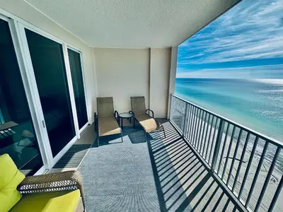 a balcony with chairs and a view of the ocean at Ocean Reef 1707 in Panama City Beach