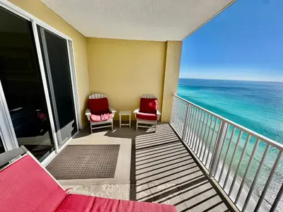 a balcony with two chairs and the ocean at Tropic Winds 2305 in Panama City Beach