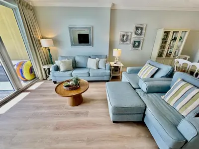 a living room with blue couches and a table at Tropic Winds 1705 in Panama City Beach