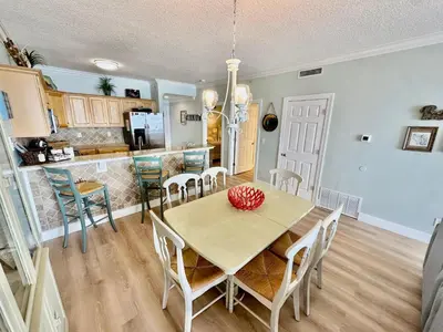 a kitchen and dining room with a table and chairs at Tropic Winds 1705 in Panama City Beach