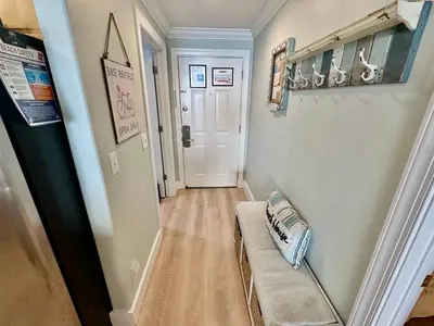 a hallway with a couch and a white door at Tropic Winds 1705 in Panama City Beach
