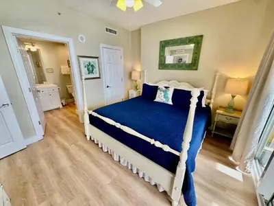 a bedroom with a bed with a blue comforter at Tropic Winds 1705 in Panama City Beach