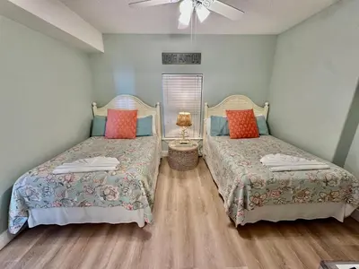 a bedroom with two beds and a ceiling fan at Tropic Winds 1705 in Panama City Beach