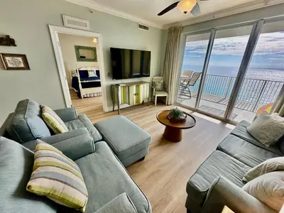 a living room with a couch and a flat screen tv at Tropic Winds 1705 in Panama City Beach
