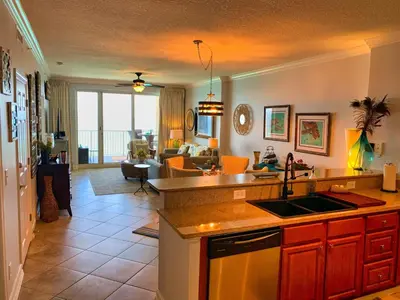 a kitchen with a sink and a living room at Ocean Reef 1403 in Panama City Beach