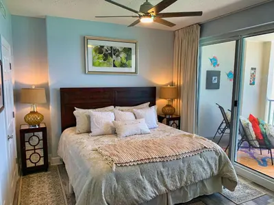 a bedroom with a bed with pillows and a ceiling fan at Ocean Reef 1403 in Panama City Beach