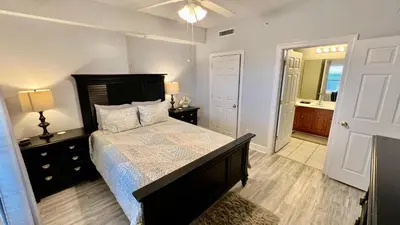 a bedroom with a large bed and a bathroom at Ocean Reef 1803 in Panama City Beach