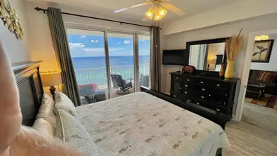 a bedroom with a bed and a view of the ocean at Ocean Reef 1803 in Panama City Beach