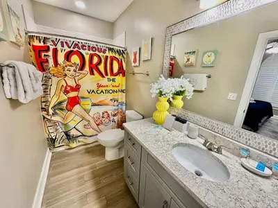 a bathroom with a movie poster on the wall at Tropic Winds 702 in Panama City Beach