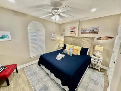 a bedroom with a blue bed with a stuffed animal on it at Tropic Winds 702 in Panama City Beach