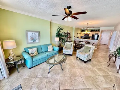 a living room with a blue couch and chairs at Ocean Reef 703 in Panama City Beach