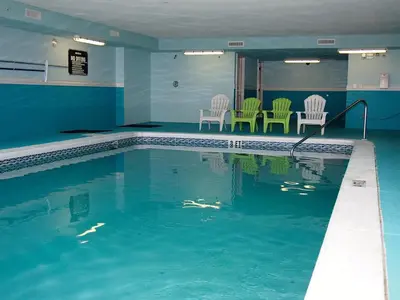 a swimming pool with chairs and chairs in a building at Ocean Reef 703 in Panama City Beach