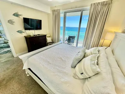 a bedroom with a bed with a view of the ocean at Ocean Reef 1102 in Panama City Beach