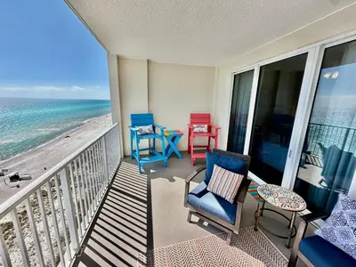 a balcony with chairs and a table and the ocean at Ocean Reef 1102 in Panama City Beach