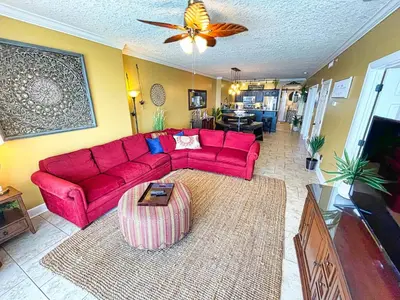 a living room with a red couch and a table at Ocean Reef 1609 in Panama City Beach