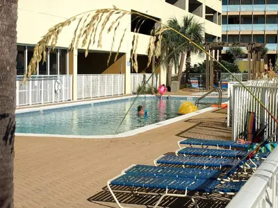 a swimming pool with blue lounge chairs in a building at Ocean Reef 1609 in Panama City Beach