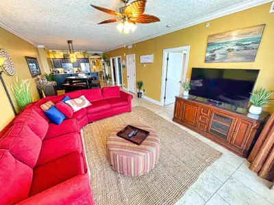 a living room with a red couch and a flat screen tv at Ocean Reef 1609 in Panama City Beach