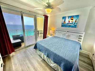 a bedroom with a bed and a view of the ocean at Tropic Winds 2302 in Panama City Beach