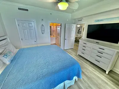 a bedroom with a bed and a flat screen tv at Tropic Winds 2302 in Panama City Beach