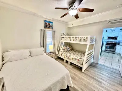 a bedroom with a white bed and a ceiling fan at Tropic Winds 2302 in Panama City Beach