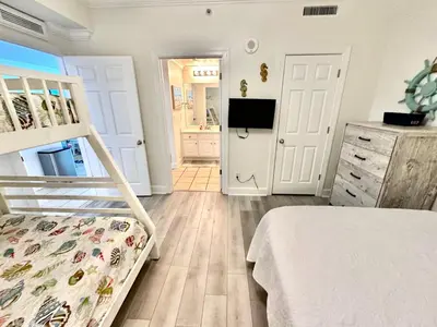 a bedroom with a bunk bed and a dresser at Tropic Winds 2302 in Panama City Beach