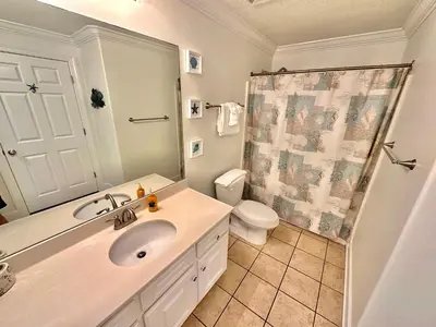 a bathroom with a sink and a toilet and a shower at Tropic Winds 2302 in Panama City Beach