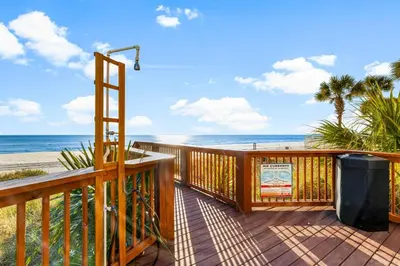 a deck with a trash can and the beach at Tropic Winds 2302 in Panama City Beach