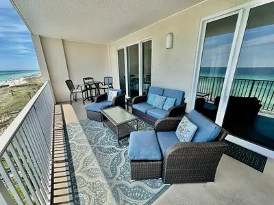 a balcony with couches and chairs and the ocean at Ocean Reef 606 in Panama City Beach