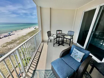 a balcony with a table and chairs and the beach at Ocean Reef 606 in Panama City Beach