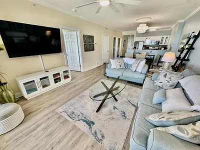 a living room with a large couch and a flat screen tv at Ocean Reef 1006 in Panama City Beach