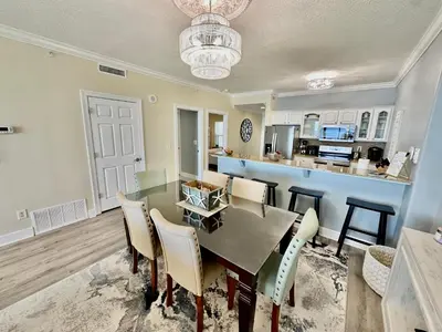 a kitchen and dining room with a table and chairs at Ocean Reef 1006 in Panama City Beach