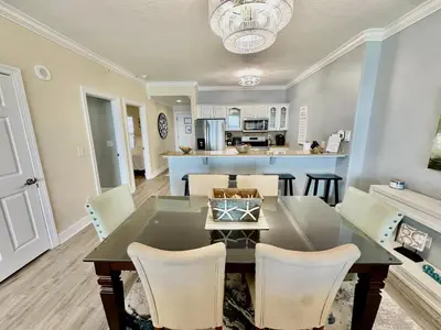 a dining room and living room with a table and chairs at Ocean Reef 1006 in Panama City Beach