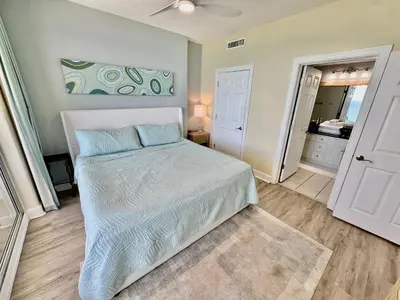 a bedroom with a white bed and a bathroom at Ocean Reef 1006 in Panama City Beach