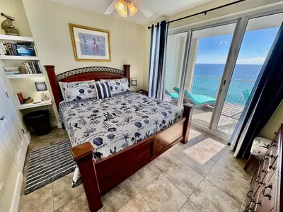 a bedroom with a bed and a view of the ocean at Ocean Reef 1507 in Panama City Beach