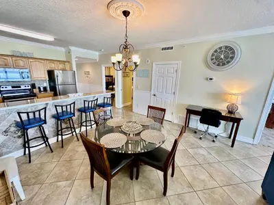 a dining room and kitchen with a table and chairs at Ocean Reef 1507 in Panama City Beach