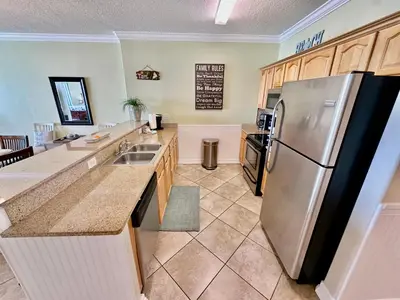 a kitchen with a stainless steel refrigerator and counters at Ocean Reef 1507 in Panama City Beach