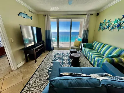 a living room with a blue couch and a flat screen tv at Ocean Reef 1507 in Panama City Beach