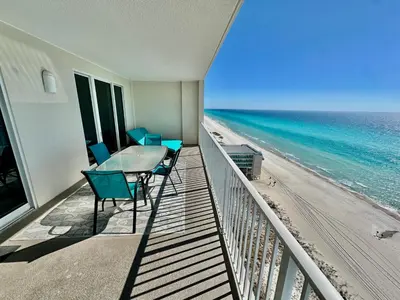 a balcony with a table and chairs and the beach at Ocean Reef 1507 in Panama City Beach