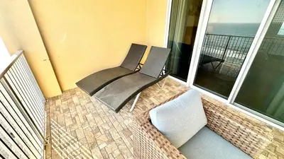 a chair sitting on a balcony with a view of the ocean at Tropic Winds 1806 in Panama City Beach