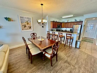 a kitchen and dining room with a table and chairs at Tropic Winds 1401 in Panama City Beach